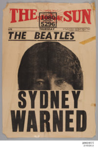 Poster advertising 'The Sun', a Sydney afternoon tabloid newspaper, dated Thursday 13 February 1964. Yellow paper with red masthead consisting of a horse chariot in front of a sunburst and the words 'The Sun'. Large photograph of the top half of John Lennon's face. The remaining text is in black, with the headline: 'The Beatles. Sydney warned'. The poster is torn in several places and has pieces of sticky tape attached.